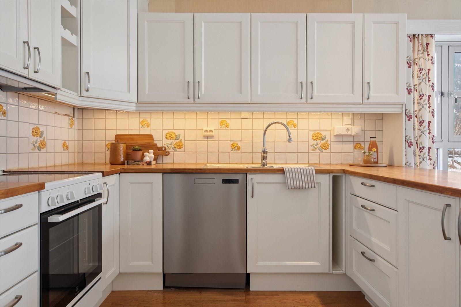 Kjøkkeninnredningen fra 2006 har profilerte fronter og en solid benkeplate i heltre. Galleribilde