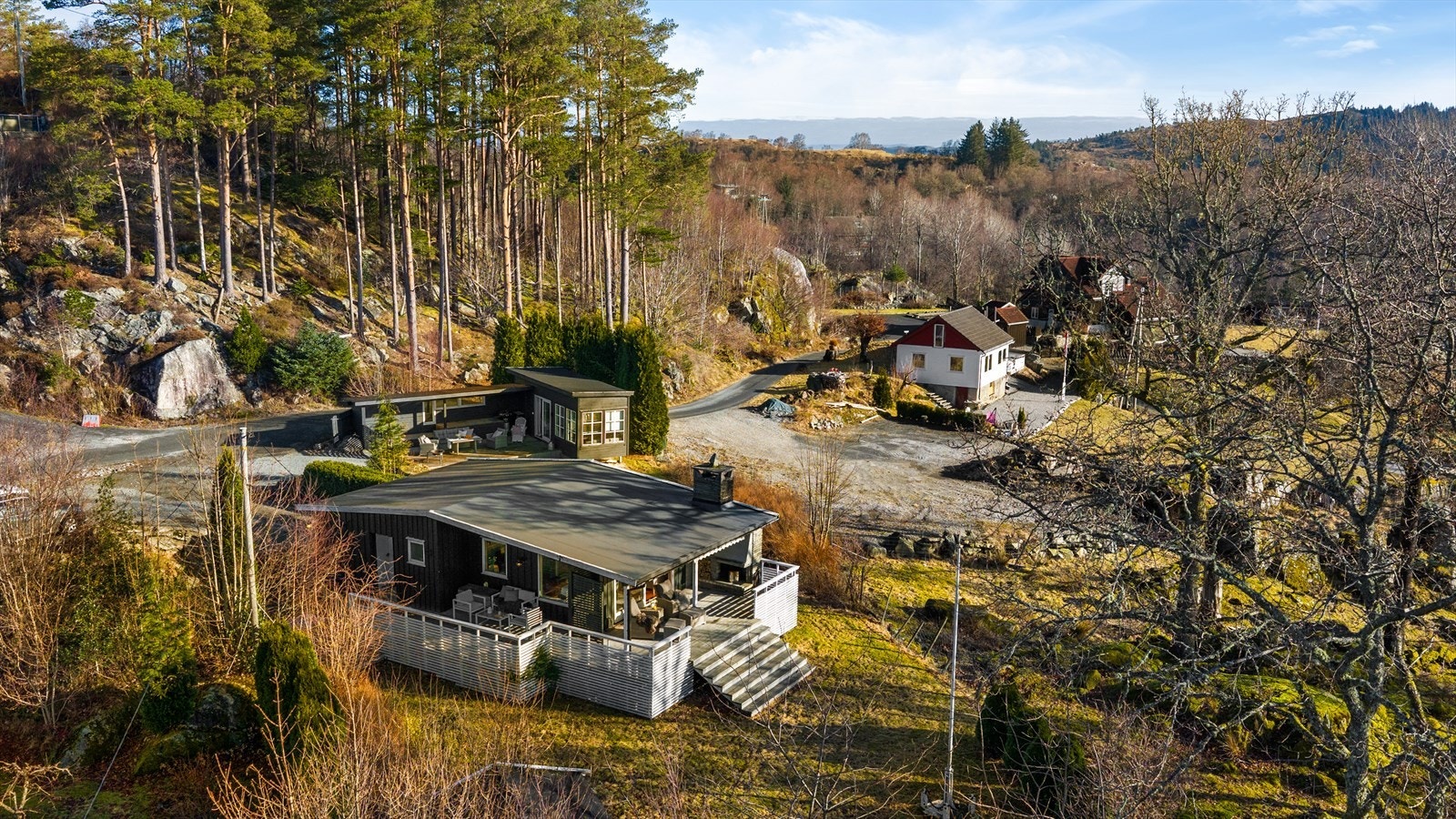 Tomten er opparbeidet med gruset område, delvis med belegningsstein, plen og noe beplantning. Galleribilde