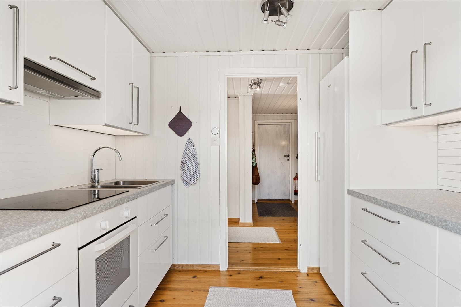 Kjøkkenet har prefabrikkert innredning med glatte fronter. Benkeplate i laminat med nedfelt servant og platetopp Galleribilde