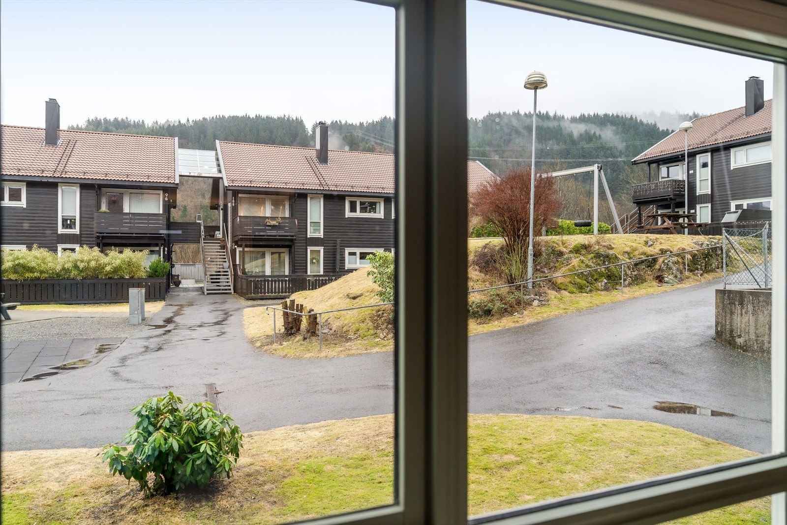 Stille og rolig tunbebyggelse med lekeplass skjermet mellom byggene Galleribilde