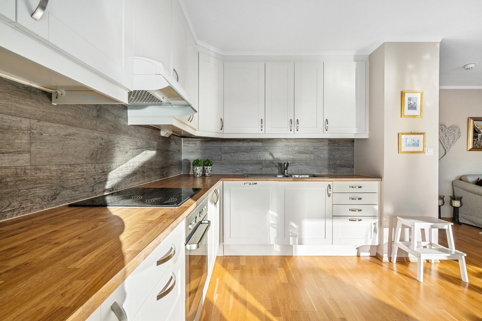 Det er sprutplate mellom benk og overskap for enklere renhold, samt en praktisk brannslange integrert i kjøkkenbenken. Galleribilde