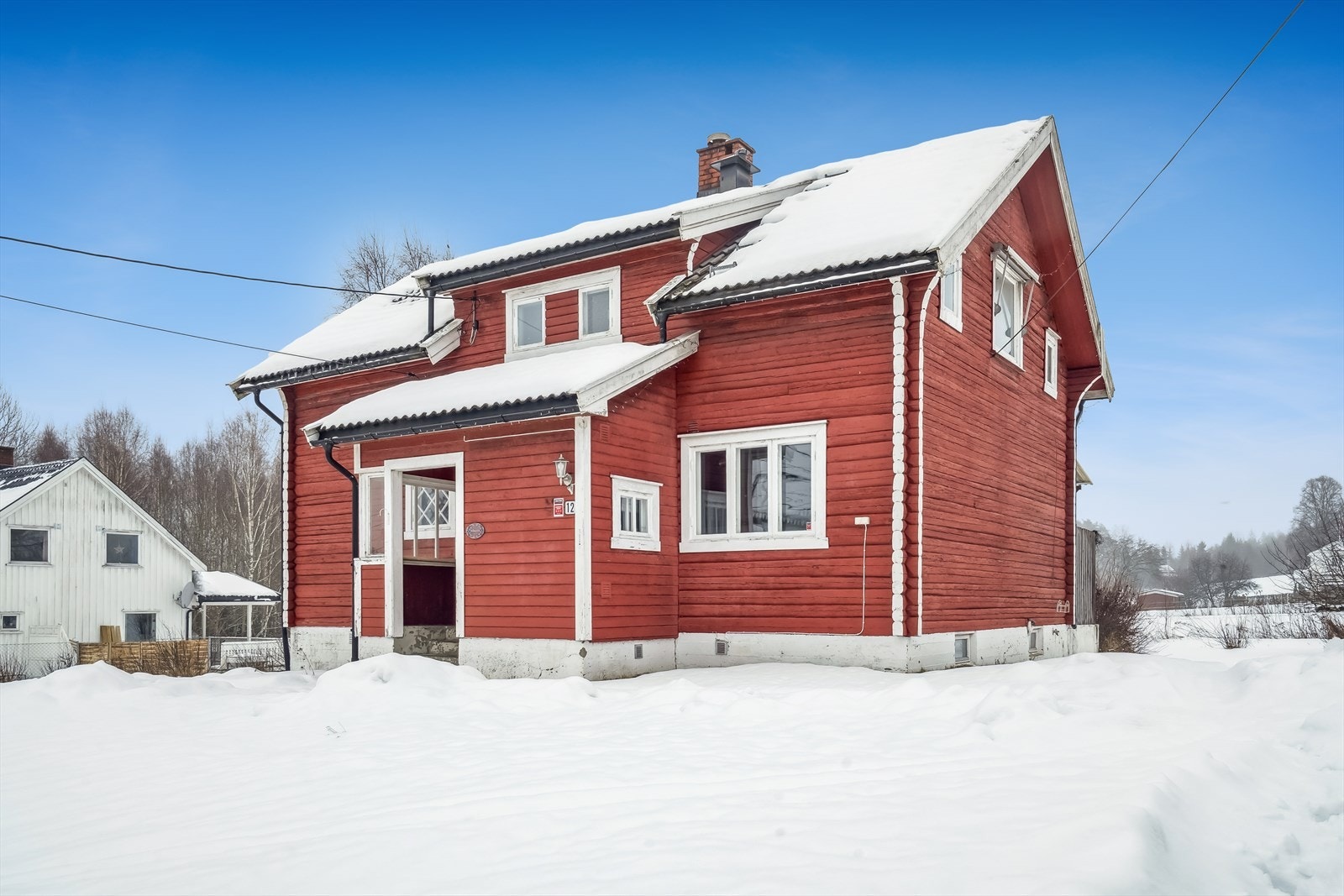 Eiendommen har en stor og solrik hage med plen, beplanting og prydbusker Galleribilde