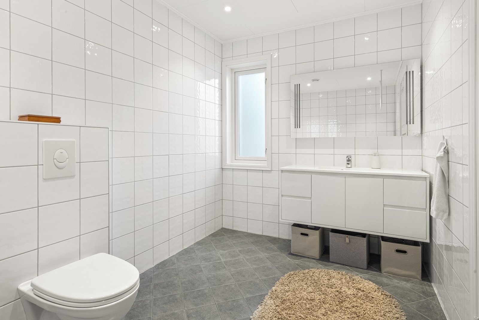 Her er det servant med skap, vegghengt toalett og varmekabler i gulvet for ekstra komfort. Galleribilde