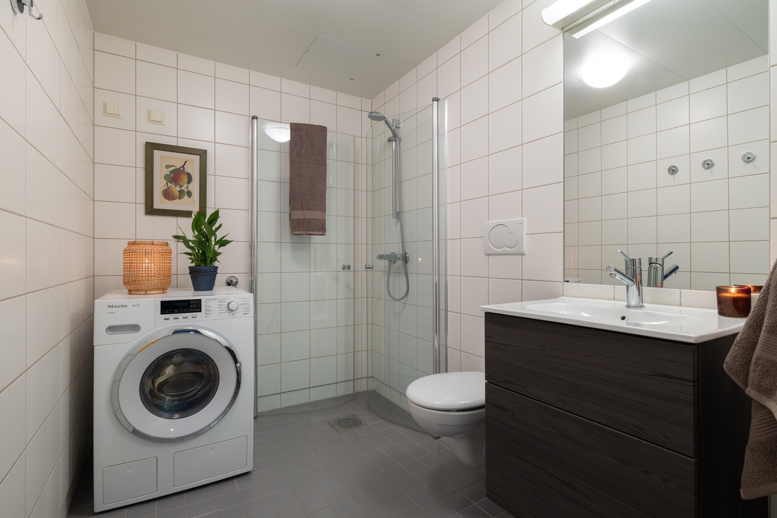 Pent, flislagt bad med varme i gulv. Det er opplegg for vaskemaskin og plass til tørketrommel. Galleribilde