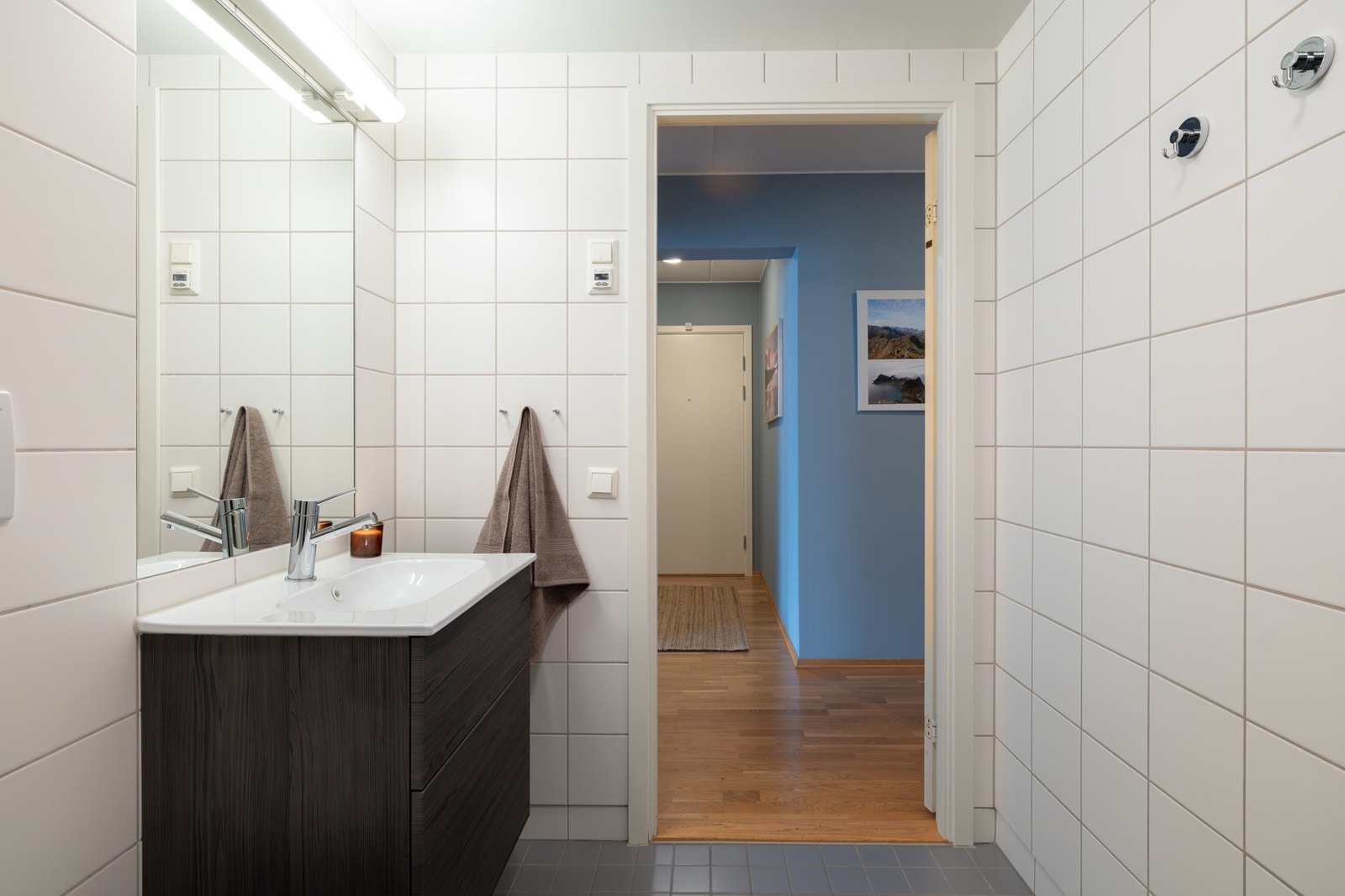 Videre er det servant på underskuffer, speil med overbelysning og stikkontakter. Galleribilde