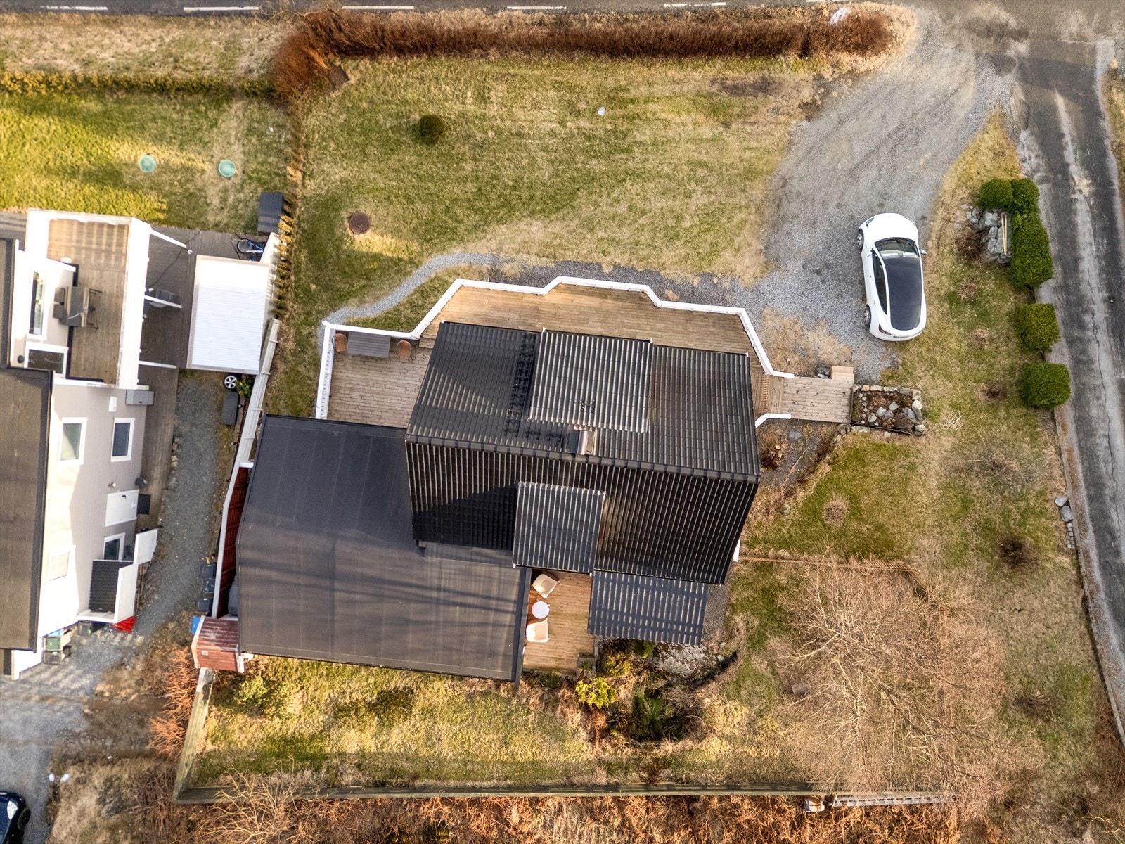 Opparbeidet tomt med bla. plen, gruset innkjørsel/parkeringsplass og stor terrasse. Galleribilde