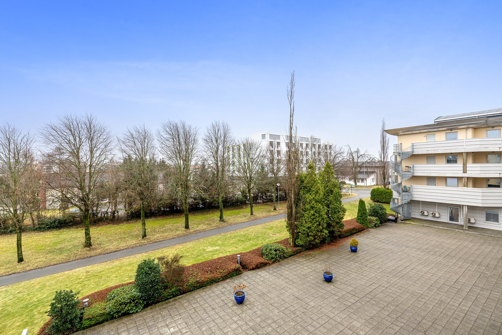Flott utsikt fra balkongen mot hyggelige fellesområder. Planlagt bussvei/trase - se punkt under regulering for mer info. Galleribilde