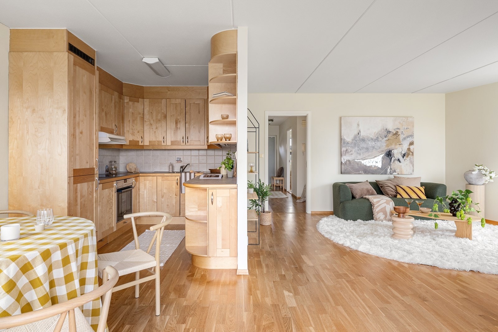 Leiligheten fremstår lys med parkett på gulvene og en åpen sosial planløsning mellom stue og kjøkken Galleribilde