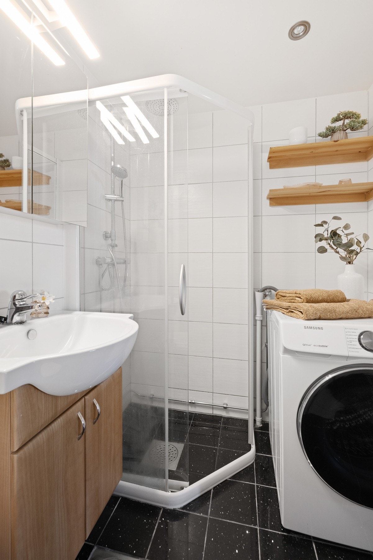 Badet har varmekabler i gulv, samt opplegg for vaskemaskin og praktiske hyller på vegg. Galleribilde