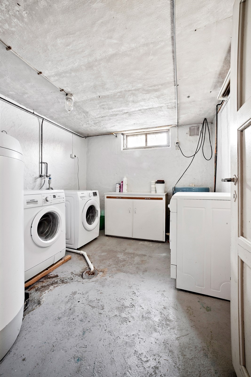 Romslig felles vaskekjeller med opplegg for vaskemaskin og god plass til tørk. Galleribilde