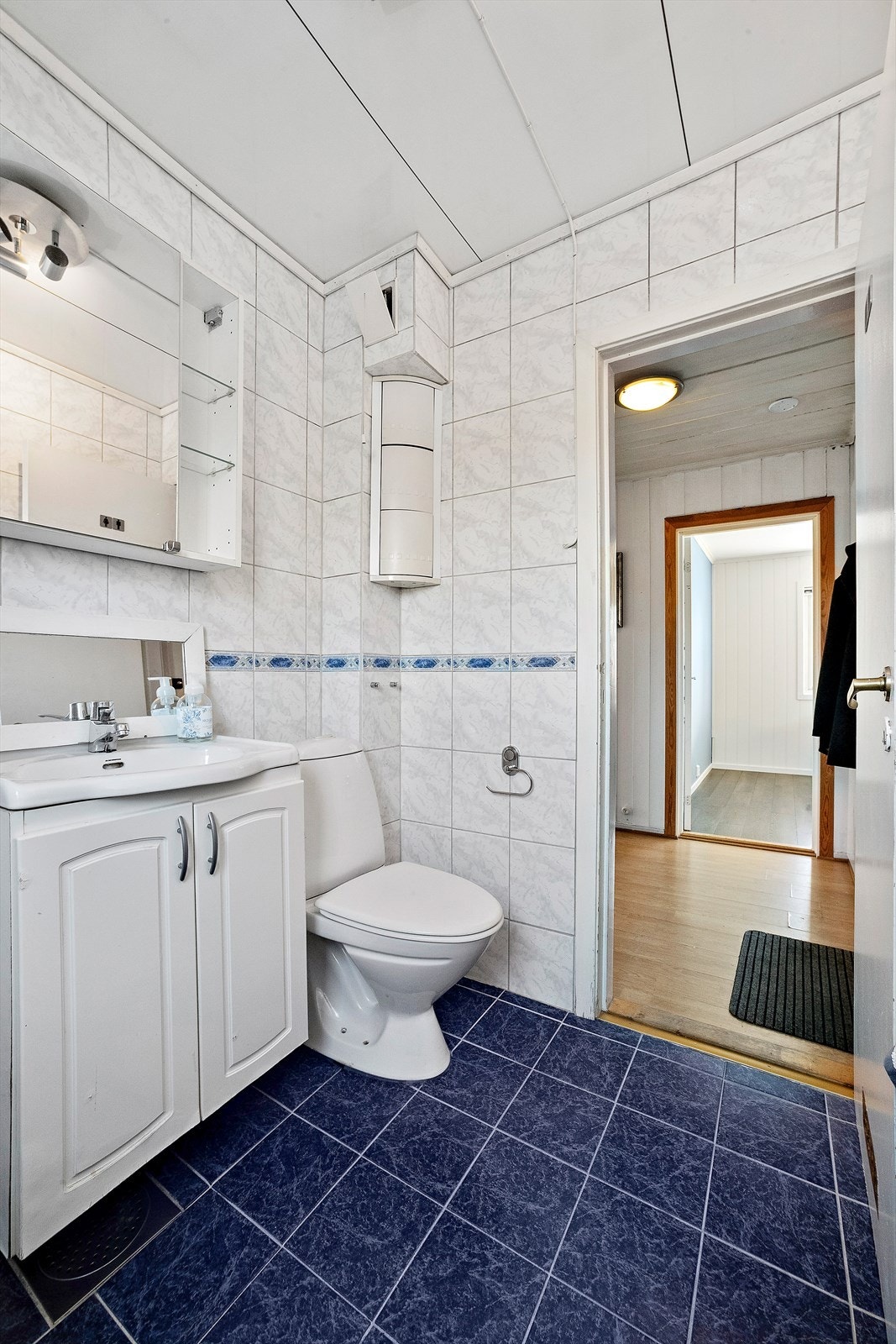 Badet er utstyrt med speilskap og vegghengt oppbevaring for god utnyttelse av plassen. Galleribilde