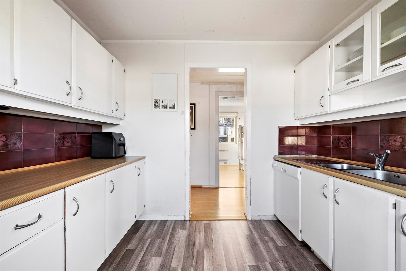 Kjøkkenet har en funksjonell utforming med arbeidsflater på hver side. Galleribilde