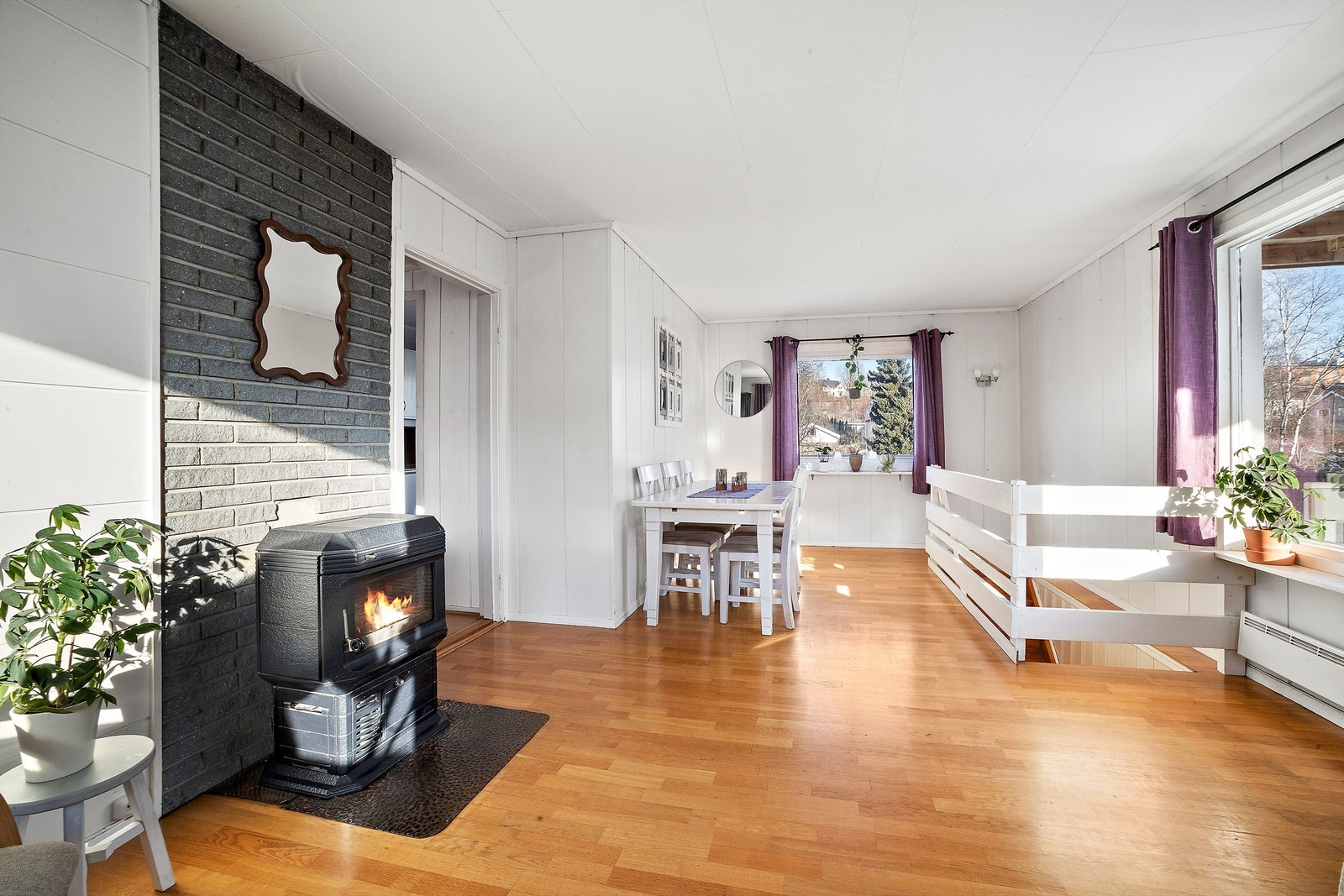 Oversikt over stuen som viser den sentrale plasseringen av vedovnen. Galleribilde