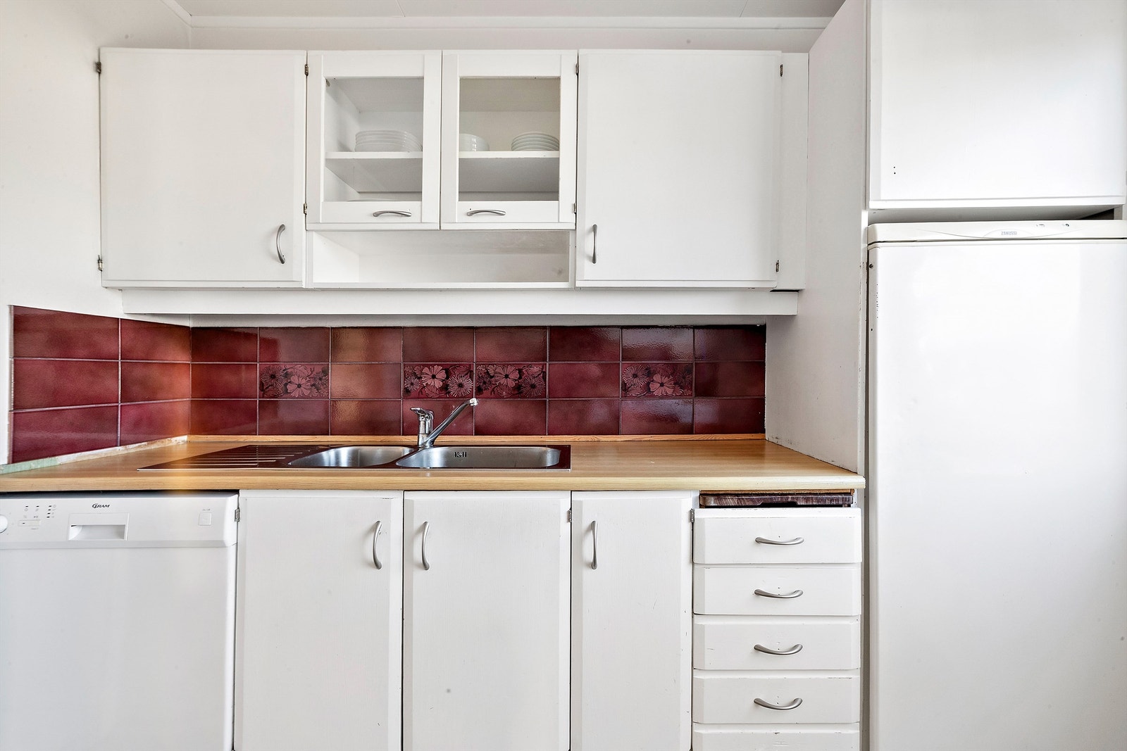 Kjøkkeninnredningen har profilerte fronter og vitrineskap. Galleribilde