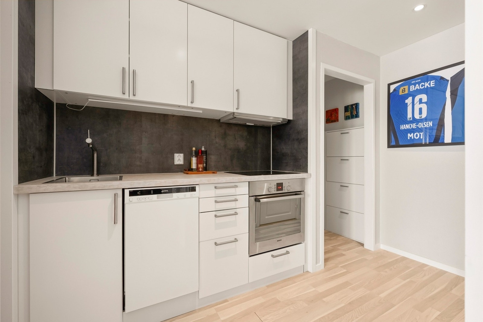 Kjøkkenet har integrerte hvitevarer bestående av platetopp, stekeovn, oppvaskmaskin og kjøl-/fryseskap, som medfølger salget. Galleribilde