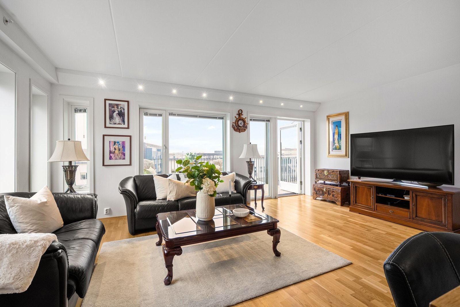 Lys og romslig stue med store vindusflater og utgang til balkong Galleribilde