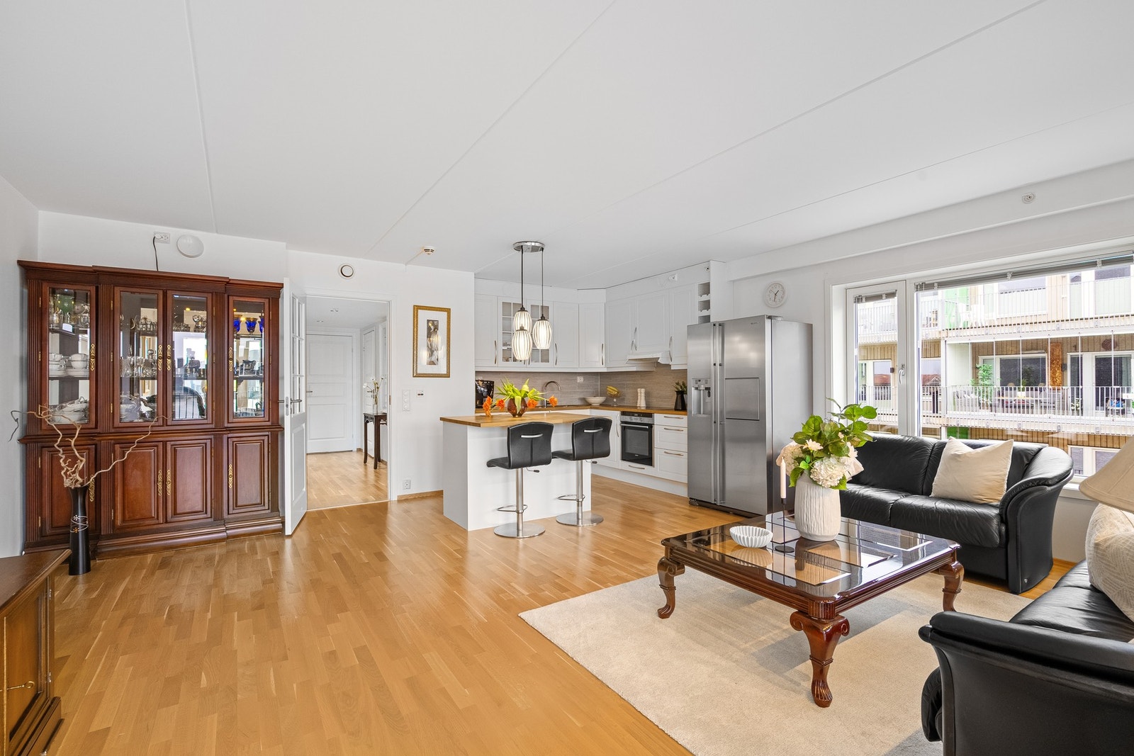 Åpen løsning mellom stue og kjøkken skaper en sosial og luftig atmosfære Galleribilde