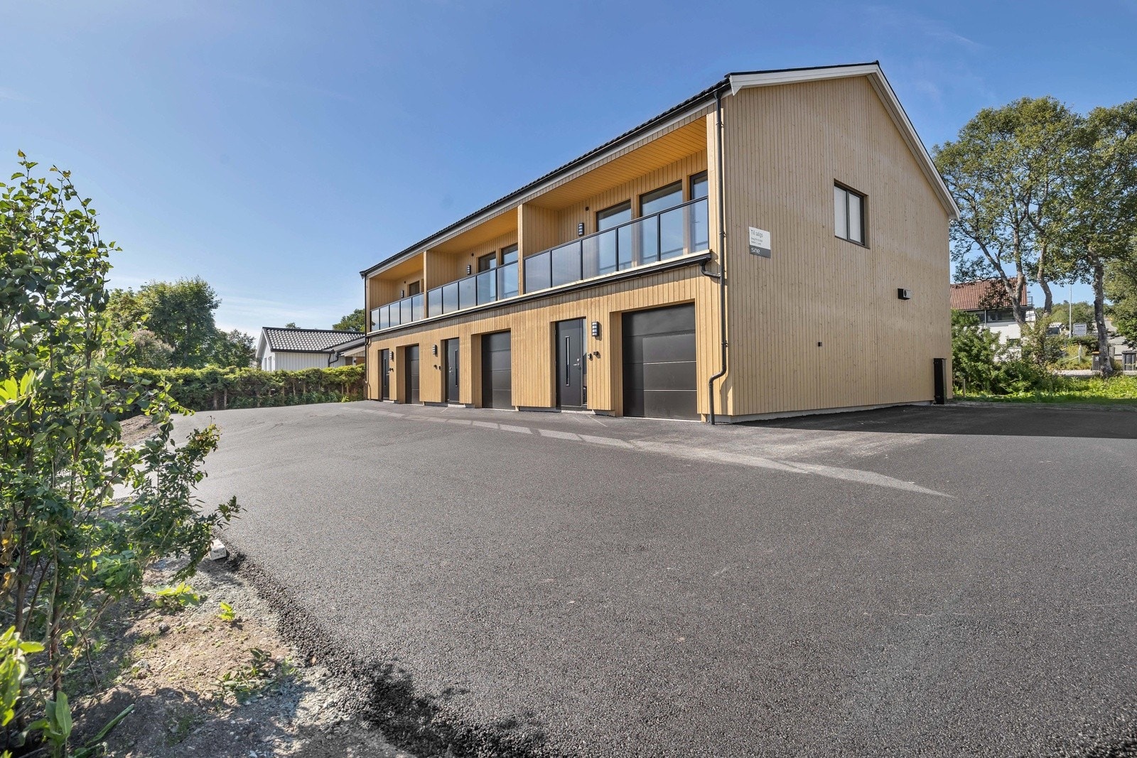 Hvert rekkehus har egen parkering i garasje, samt gjesteparkering på asfalt. Galleribilde