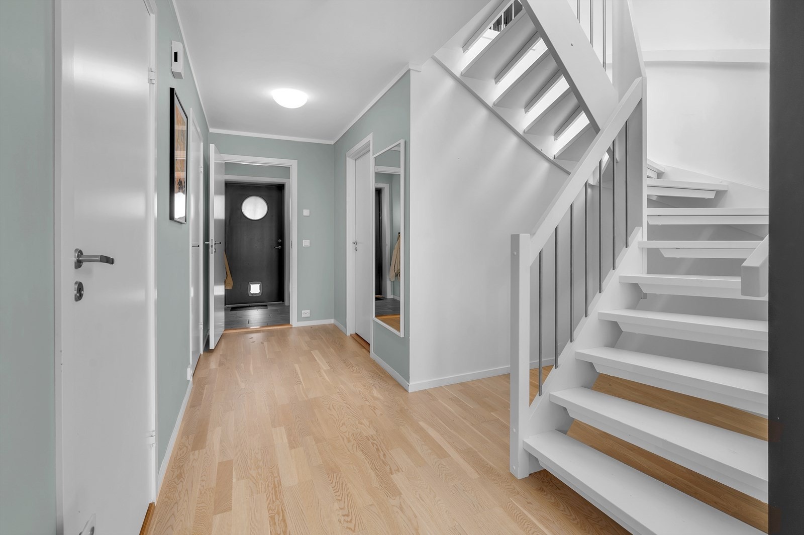 Romslig gang med plass til oppbevaring og praktisk lagringsareal under trappen. Galleribilde