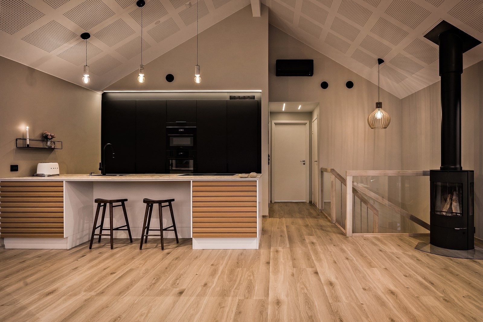 Boligens moderne kjøkken er utstyrt med en praktisk innredning som kombinerer slette fronter med profilerte eikefronter for et elegant utseende. Benkeplaten i robust kompaktlaminat. Galleribilde