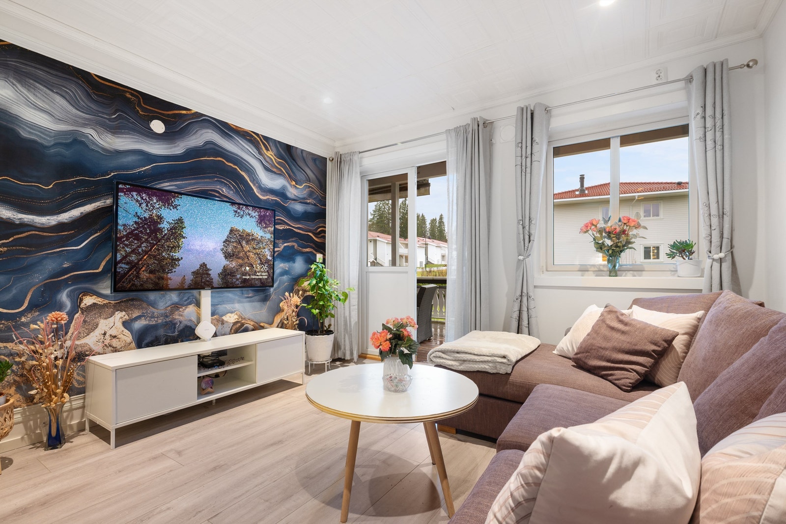 Stue med store vinder som gir mye naturlig lys Galleribilde