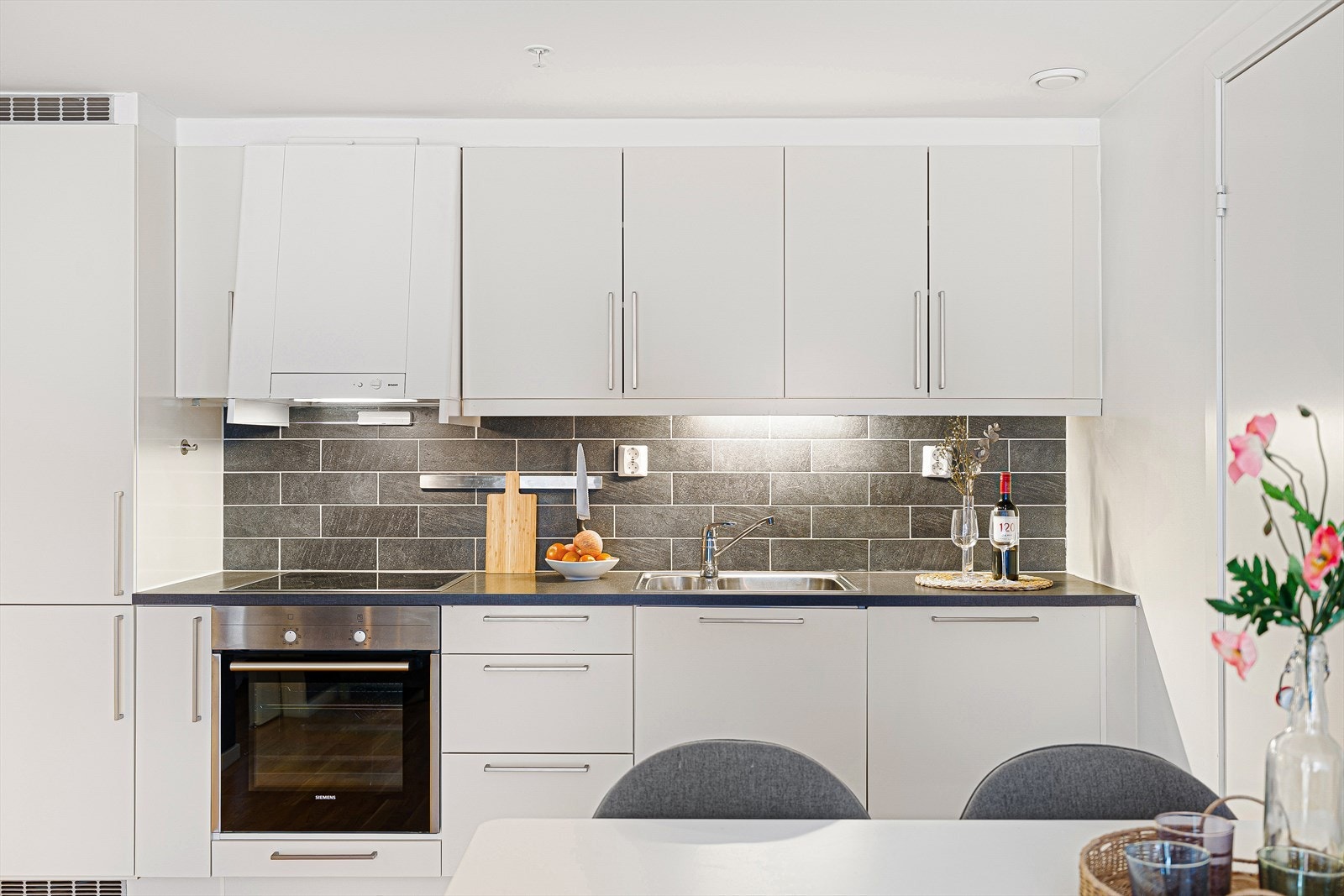 Kjøkkenet er levert av kvalitetsleverandøren HTH og har hvite, slette fronter og integrerte hvitevarer. Her har man et funksjonelt og praktisk kjøkken i en moderne og tidløs utførelse, som har godt med skap- og benkeplass for kokkelering og oppbevaring. Galleribilde