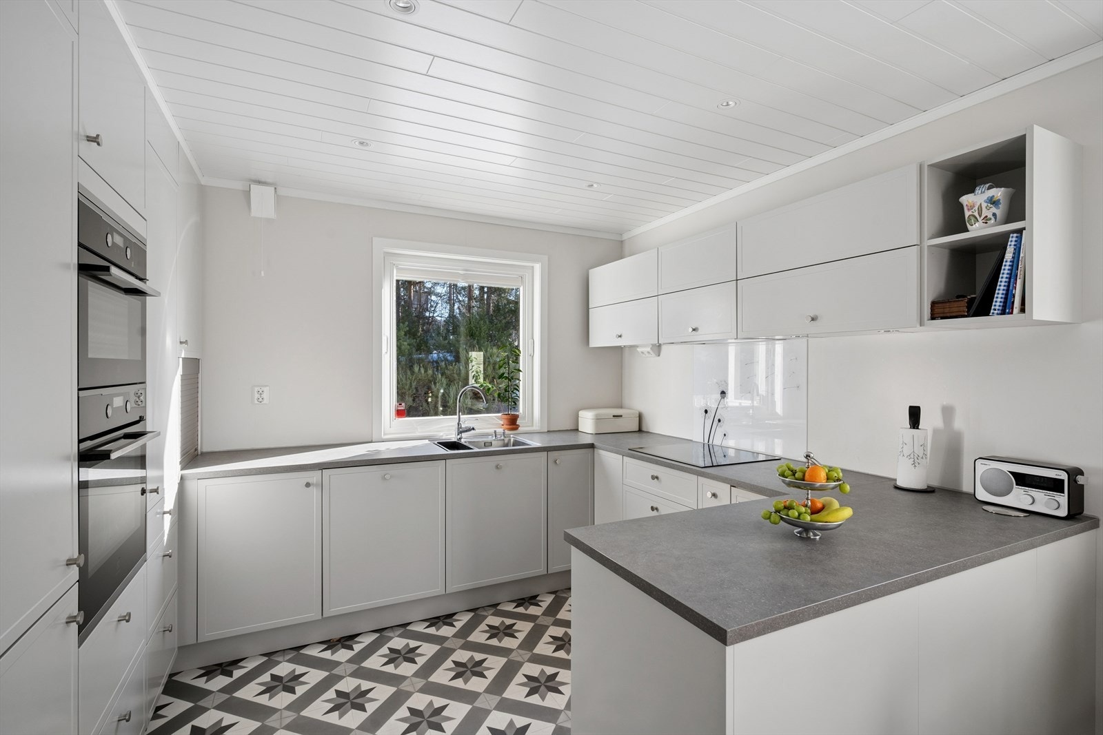 Kjøkkenet har profilerte fronter i fargen comfort grey og en mørkere benkeplate som gir et stilrent og tidløst uttrykk. Galleribilde