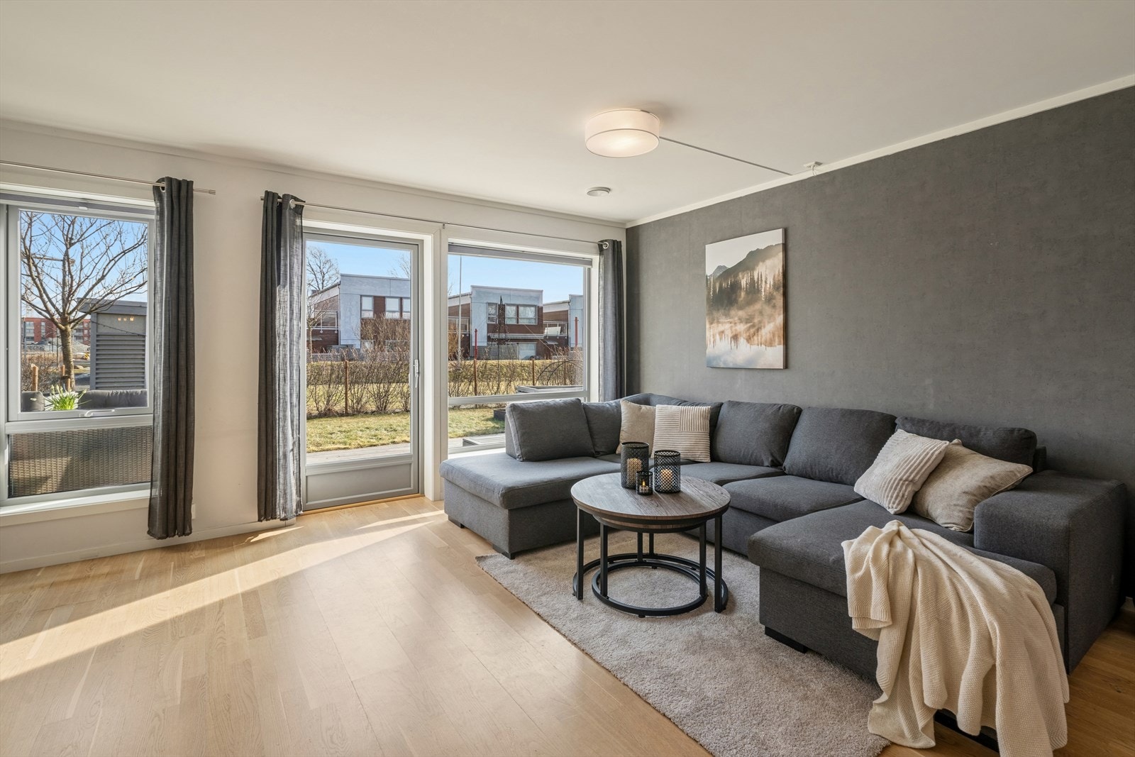 Store vindusflater og terrassedør slipper inn rikelig med naturlig lys og gir stuen en lys og luftig atmosfære. Galleribilde