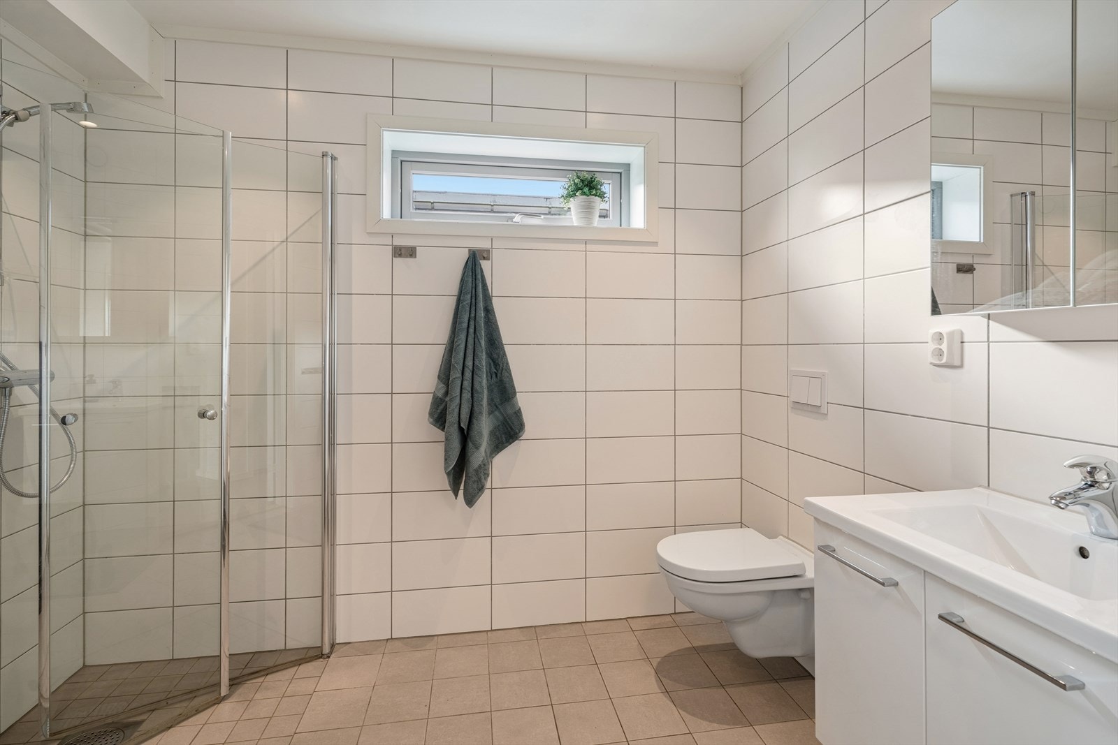Baderommet i 2. etg. er romslig og lyst med flislagte overflater og varme i gulvet. Galleribilde