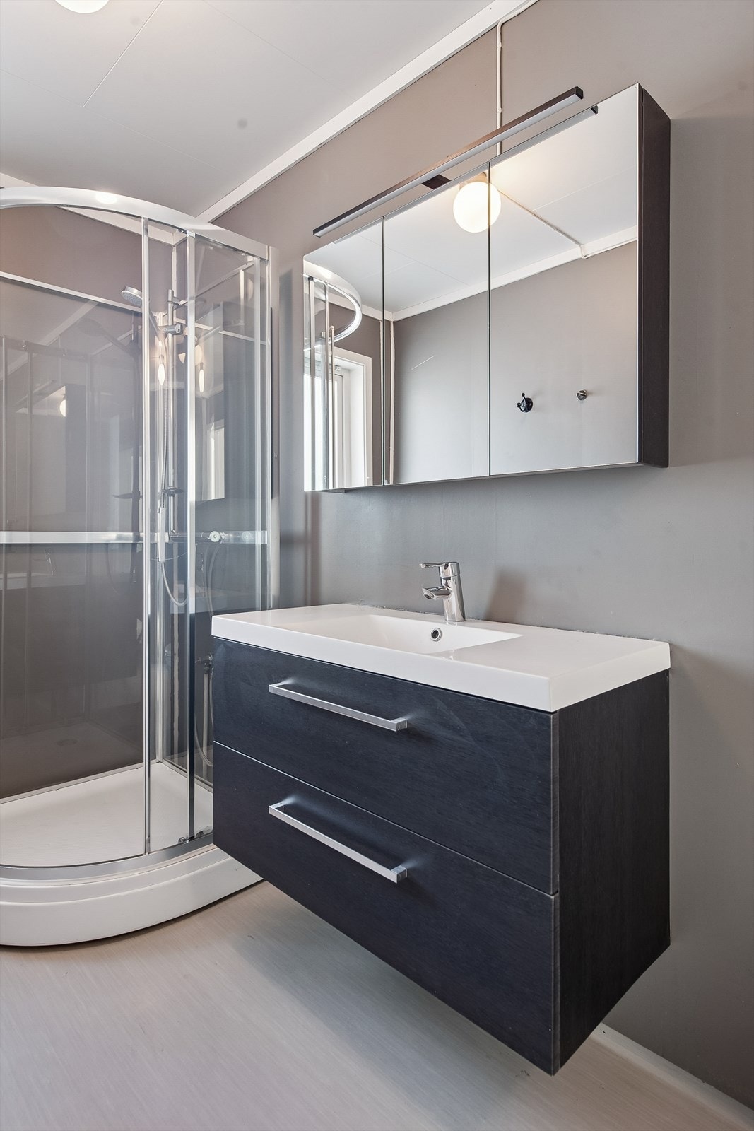 Servantinnredning med skuffer og et praktisk speilskap med integrert belysning. Galleribilde