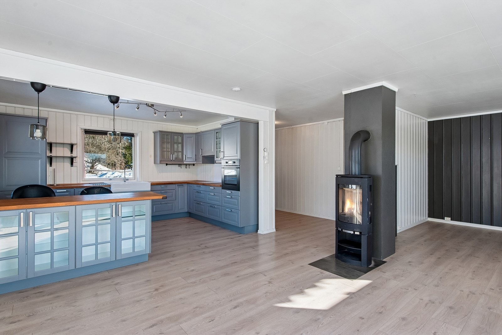 En vedovn med elementpipe gir supplerende varme og en hyggelig stemning i hovedetasjen. Galleribilde