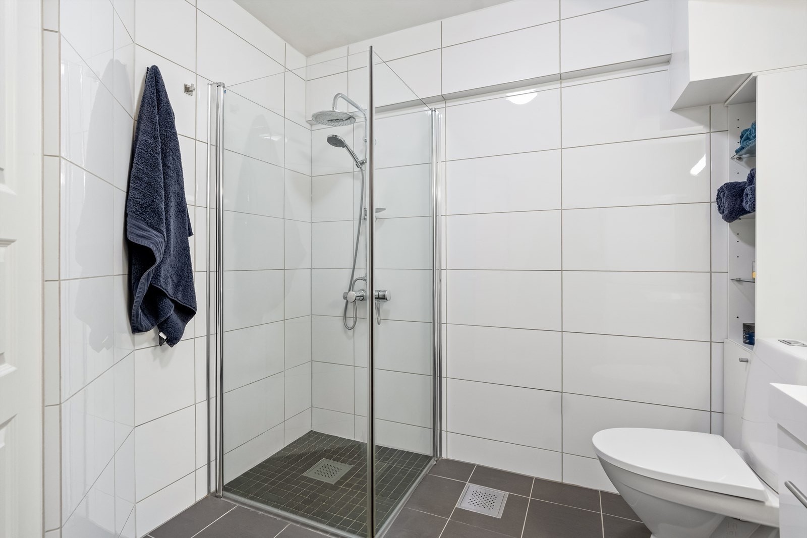 Innredningen består av skap med glatte fronter, servant, gulvstående klosett, dusj på gulv og opplegg for vaskemaskin. Galleribilde