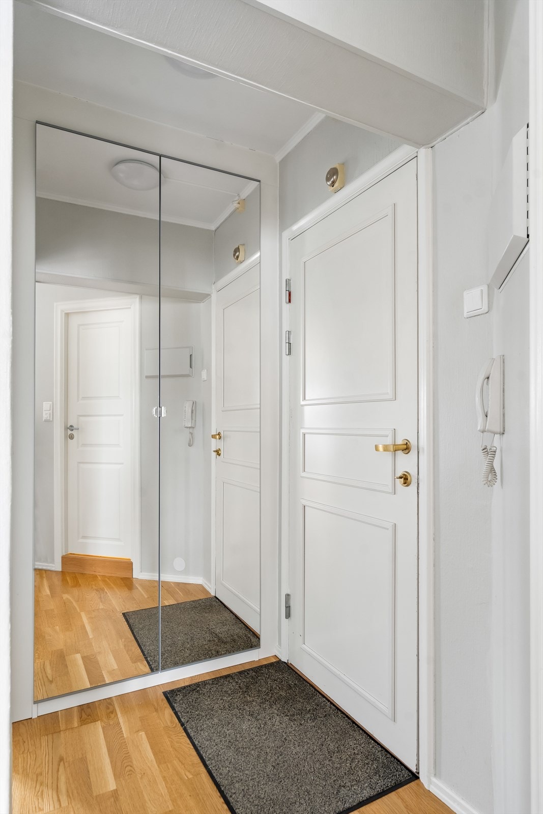 Boligen har en lys entré med plass til å henge fra seg yttertøy og sette fra seg sko i garderobeskap med speilfronter. Galleribilde