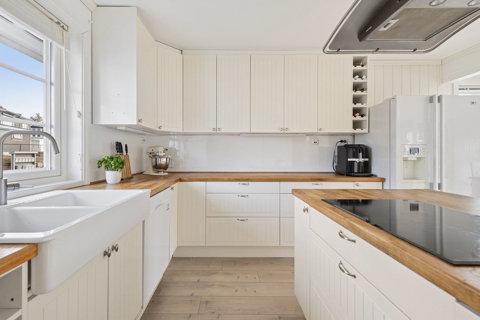 IKEA kjøkkeninnredning med profilerte fronter, heltre benkeplate og en solid keramisk vask. Galleribilde