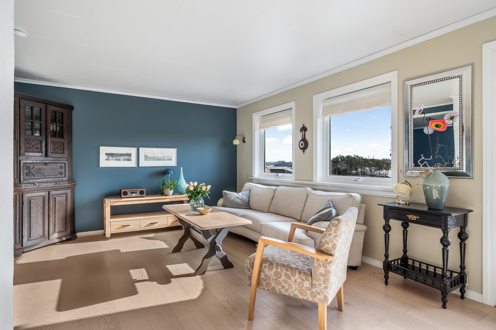 Fint fargevalg i stua og den flotte utsikten mot fjorden kan nytes fra flere hold. Galleribilde