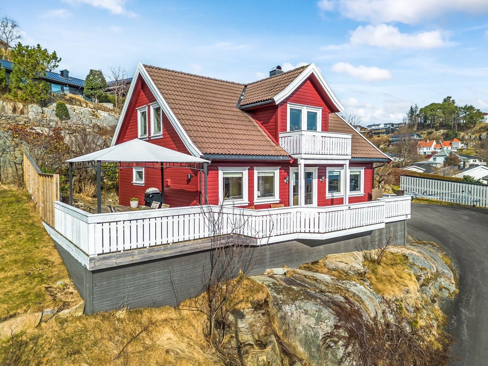 Solrikt beliggende enebolig på en høyde med asfaltert oppkjørsel og tun. Galleribilde