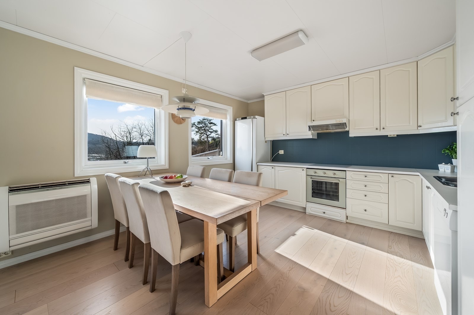 Pent profilert kjøkken med integrert komfyr og enkeltstående hvitevarer. Kjøkkenet har en sosial løsning med naturlig plass til spisemøblement. Galleribilde