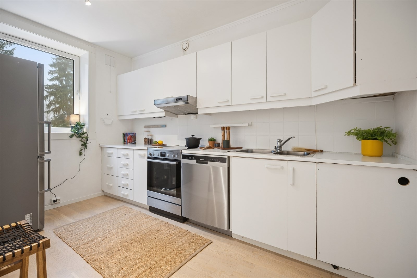 Kjøkkenet er innredet med overmalte, glatte fronter og en laminat benkeplate. Galleribilde