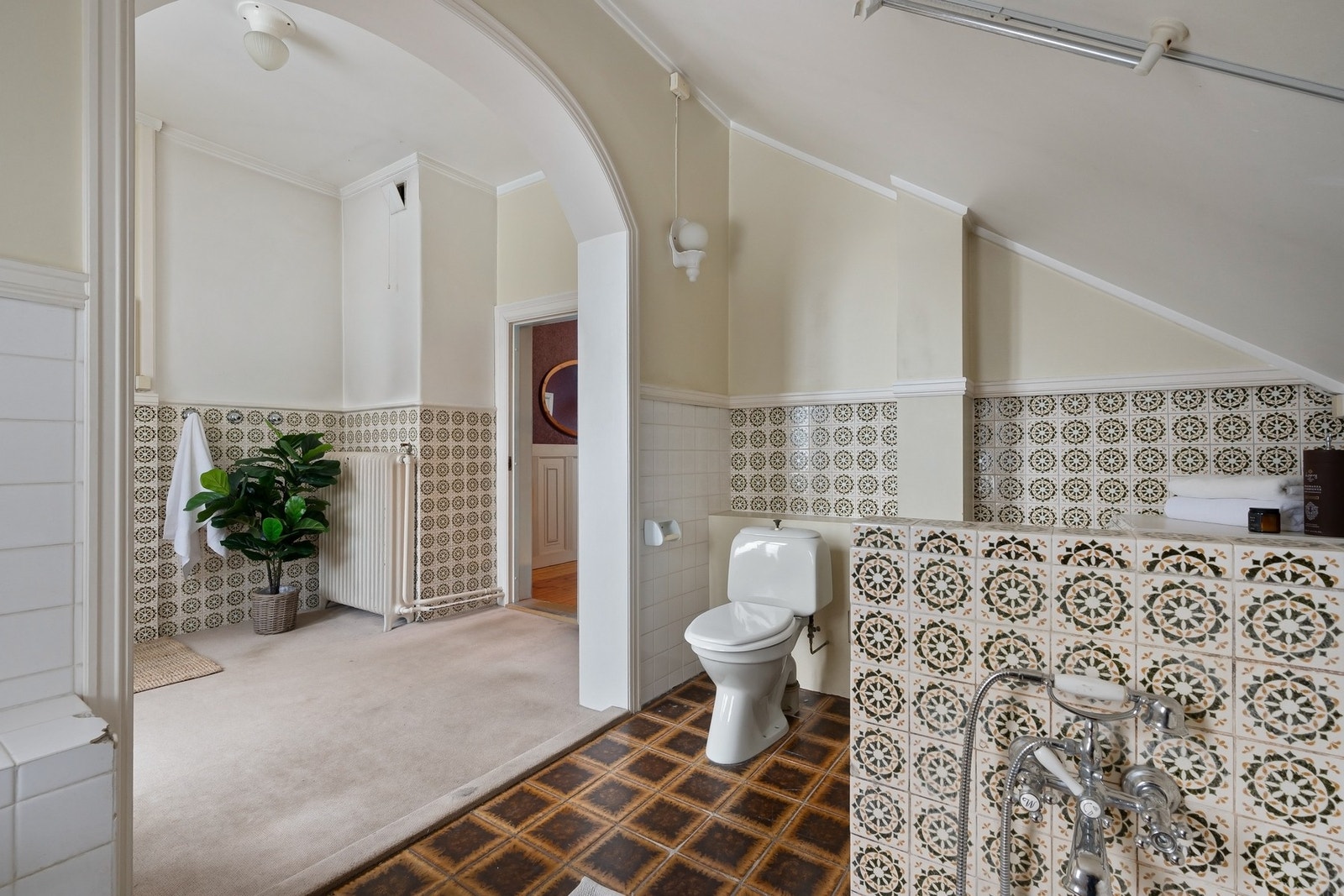 Romslig bad i annen-etasje, med behov for rehabilitering. Badet er innredet med søyleservant, toalett og dusj. I tilstøtende rom, med teppegulv, er det også montert servant. Galleribilde