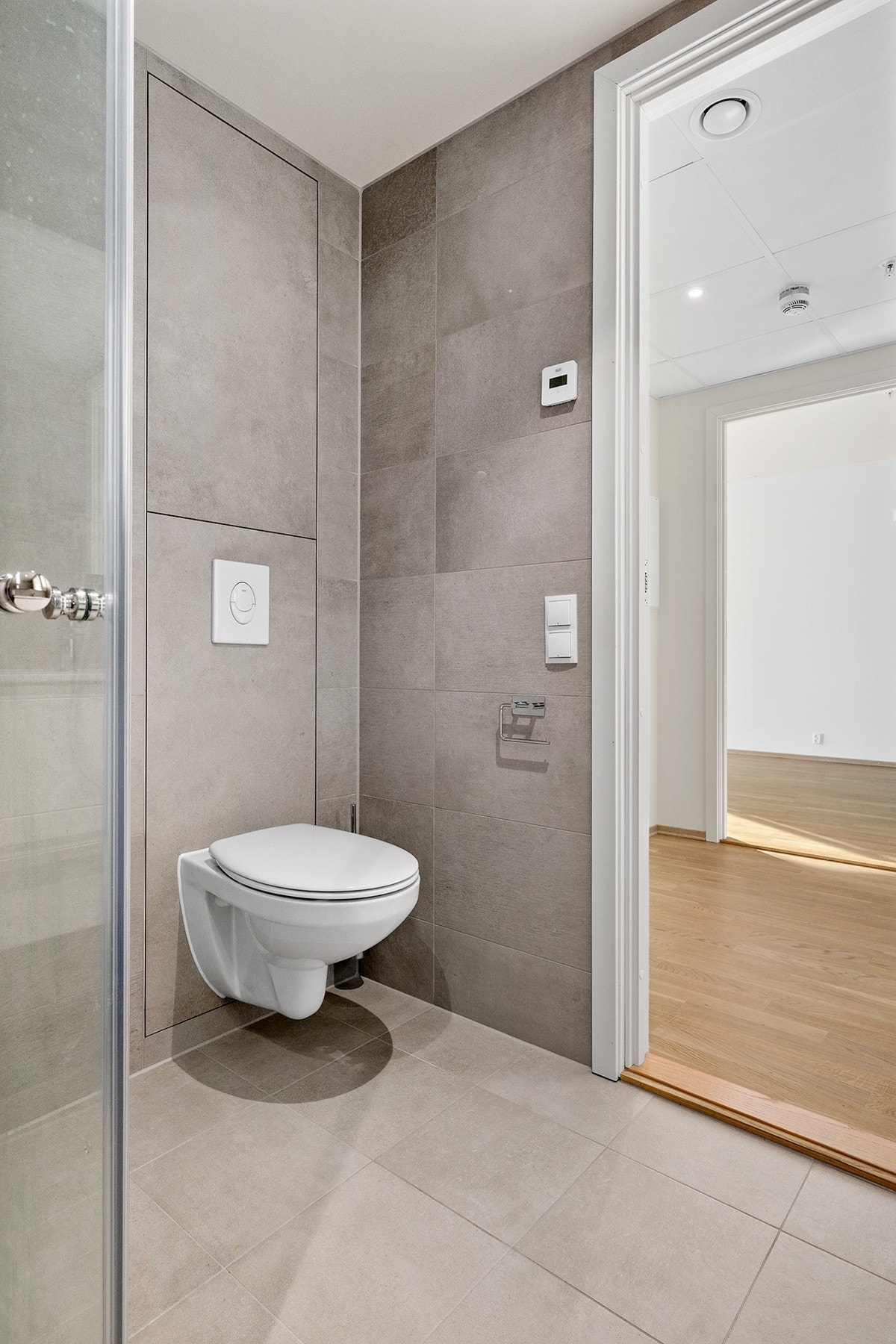 Videre er badet utstyrt med dusjhjørne og vegghengt toalett Galleribilde