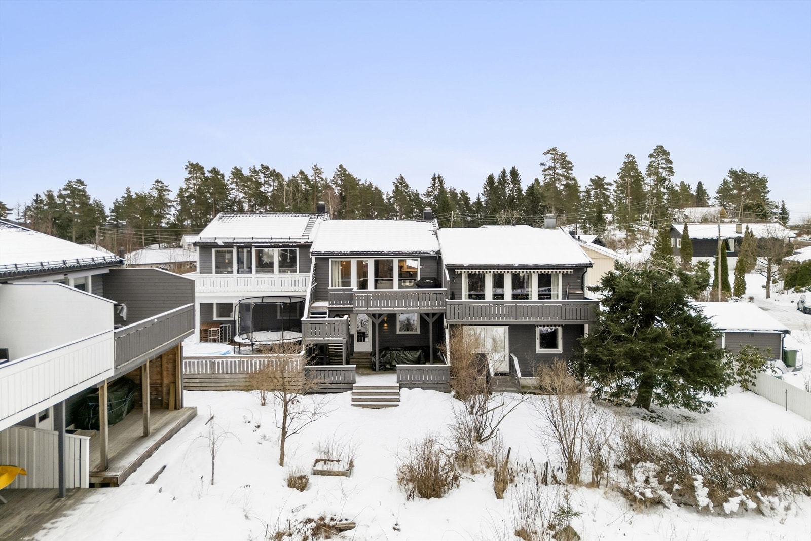 Fasade mot vest med veranda, terrasse og gressplen. Galleribilde