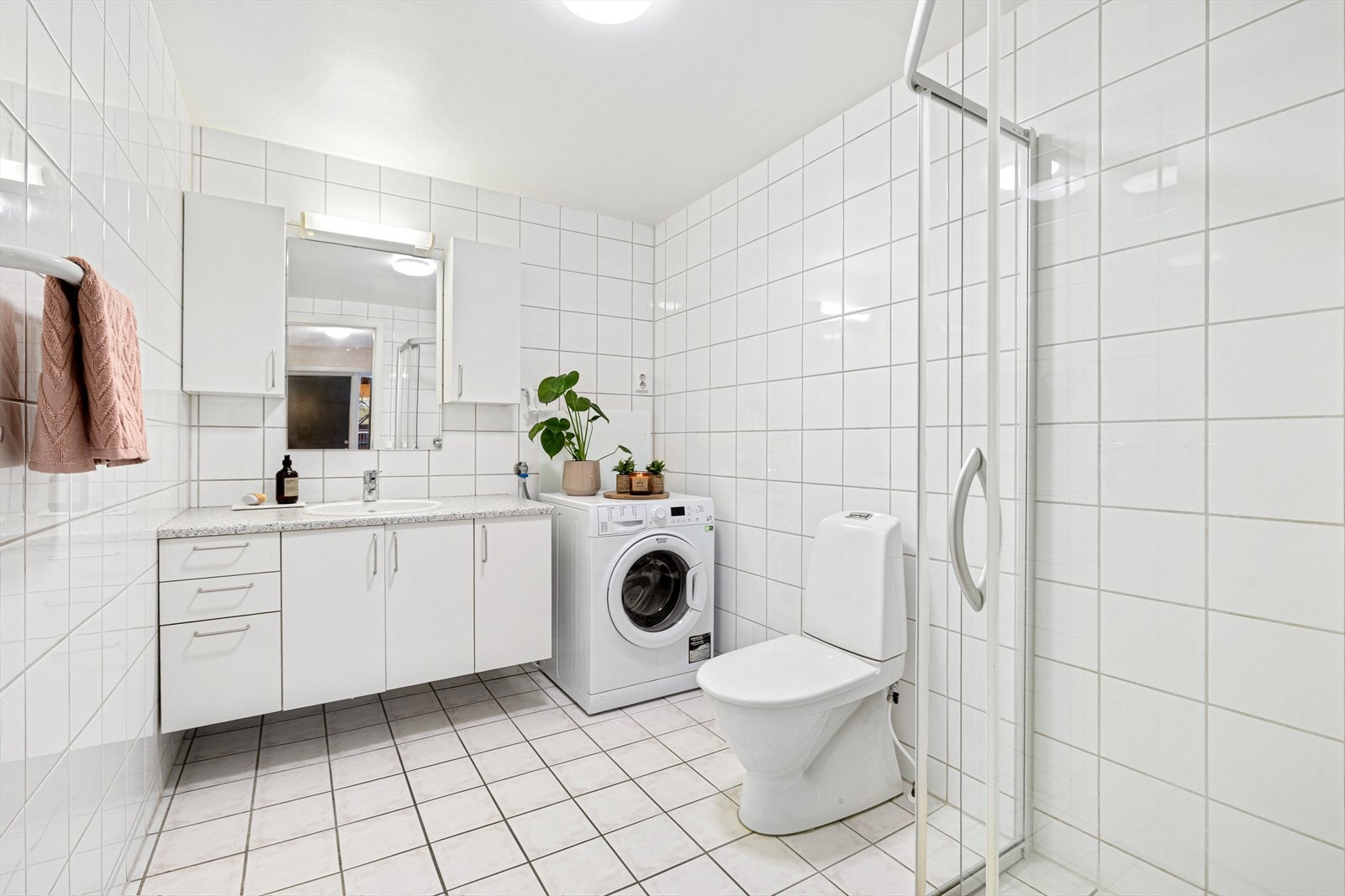 Det 6 m² store badet fremstår som innbydende med lyse, helflisede overflater, og behagelig gulvvarme. Galleribilde