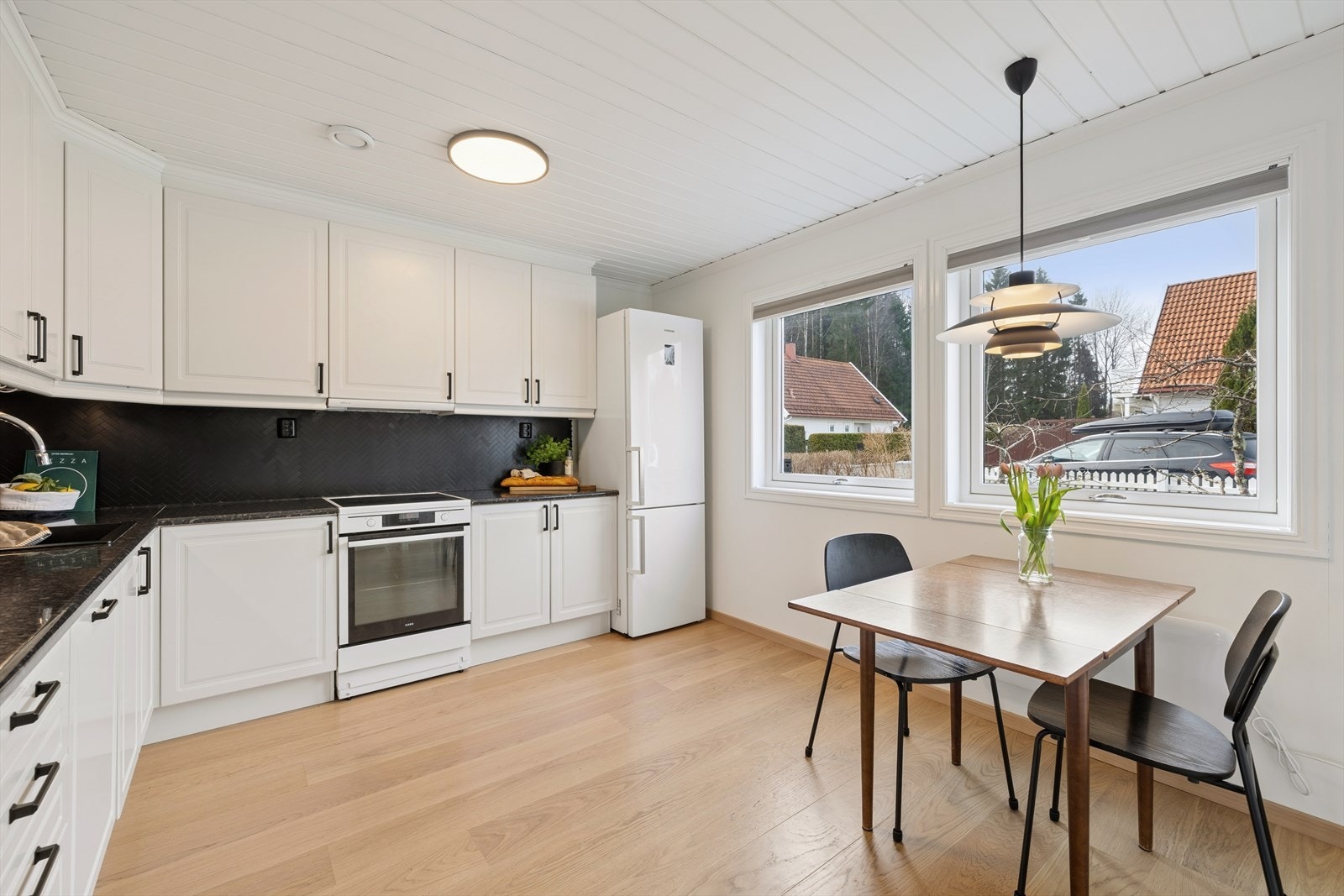 Under de store vinduene er det en koselig plass til kjøkkenbord hvor hverdagsmåltidene kan inntas. Galleribilde