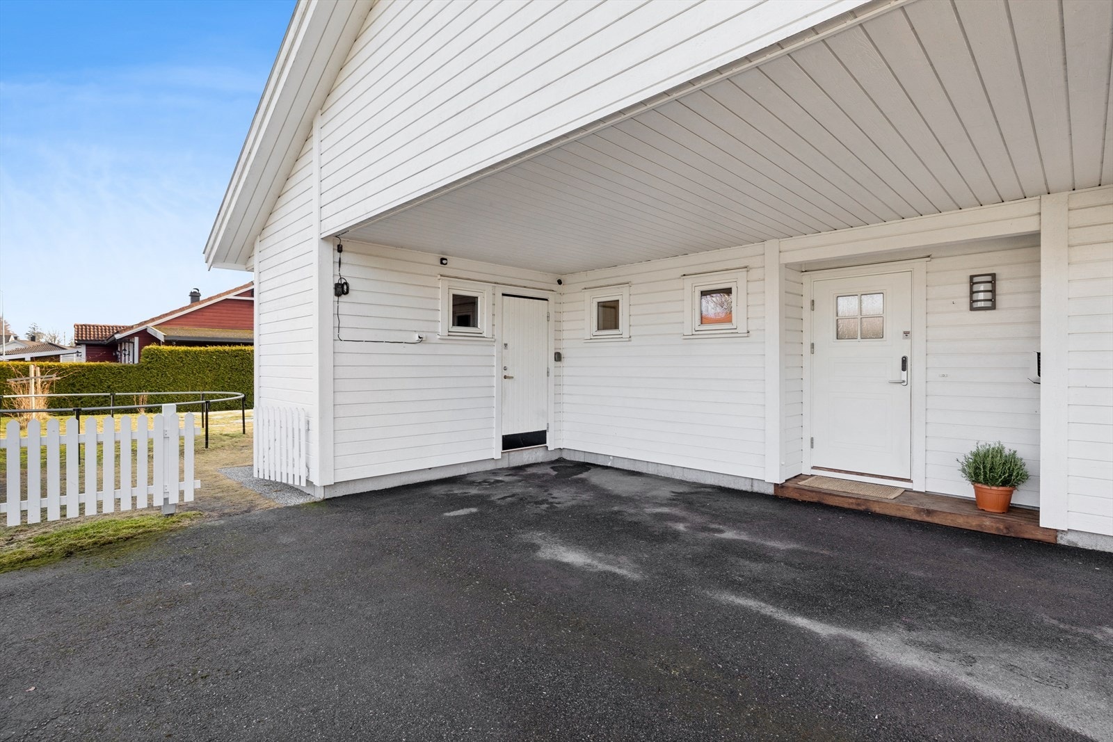 I den asfalterte gårdsplassen er det overbygget carport på ca. 20 m² som har el-bil lader montert. Her er det også en utvendig bod på ca. 6 m². Galleribilde
