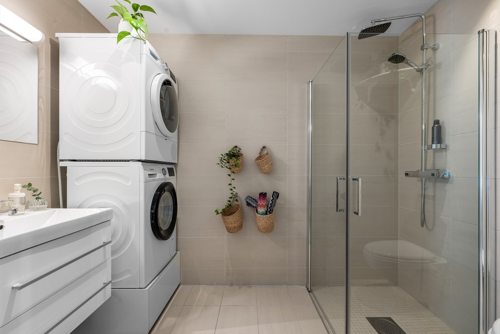 Etasjens andre bad er også flislagt og har opplegg for vaskemaskin og tørketrommel. Galleribilde