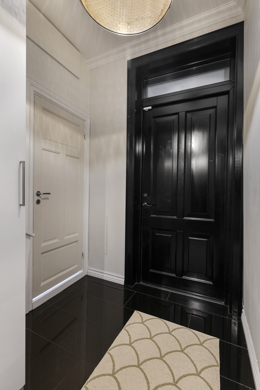 Døren til baktrappen matcher inngangsdøren og skaper en gjennomført stil. Bakdøren fører rett opp til den ene av to felles takterrasser samt leilighetens loftsbod. Galleribilde