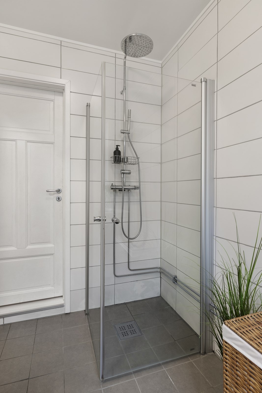 Flislagt bad med romslig dusjsone med takdusj og hånddusj. Galleribilde