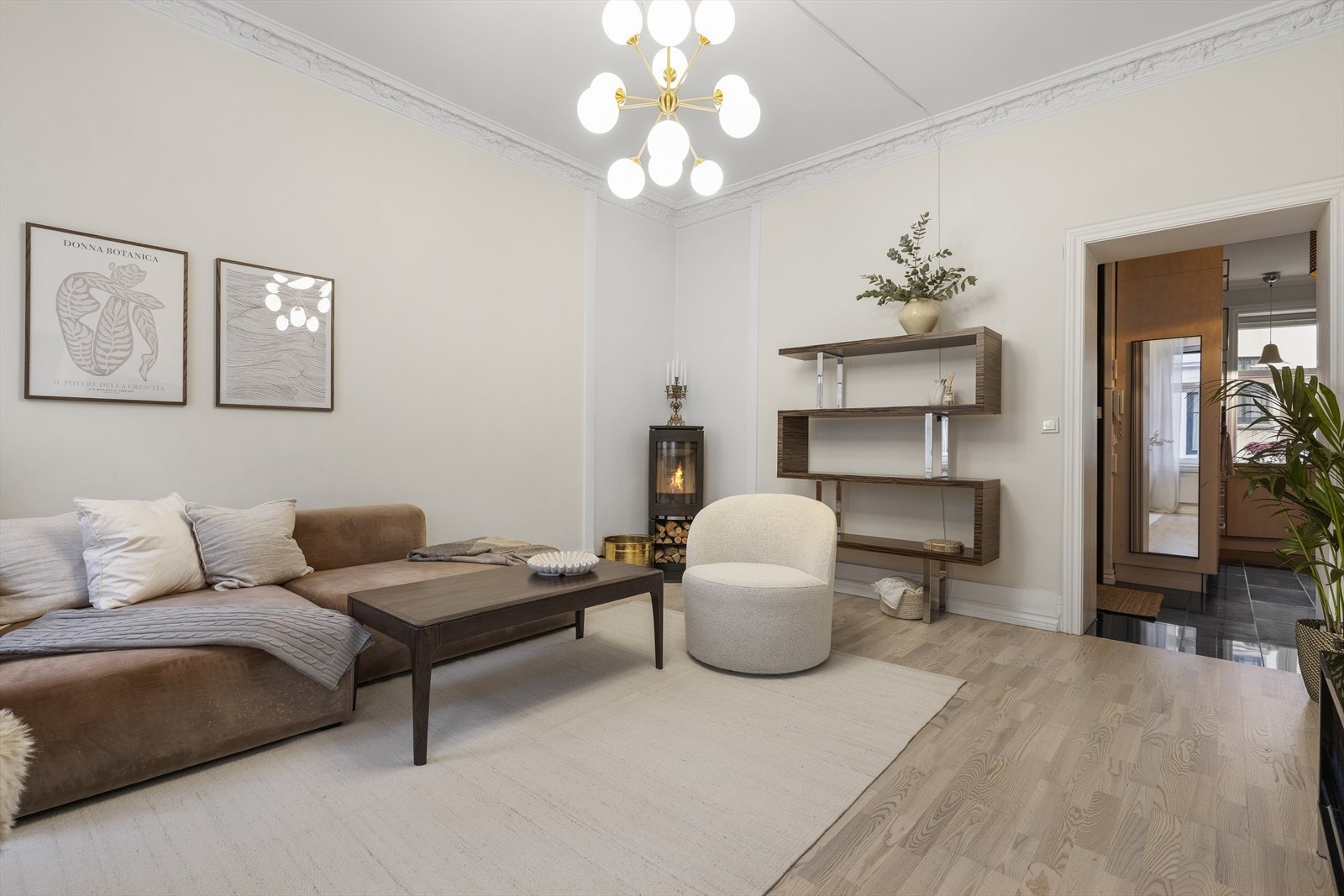 Den lekre stuen med stukkatur, rosett og peis har en naturlig og god forbindelse til kjøkkenet. Galleribilde