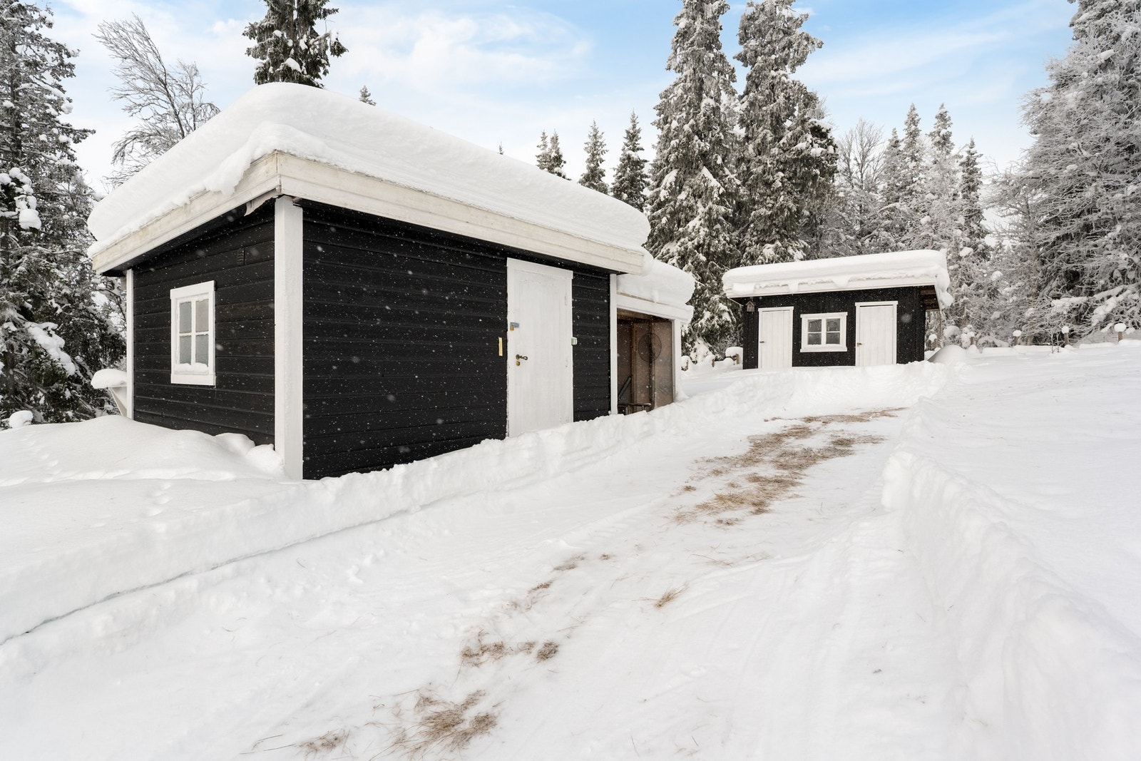 To uthus på eiendommen, ene med lagringsplass og ene med utedo og skåle Galleribilde