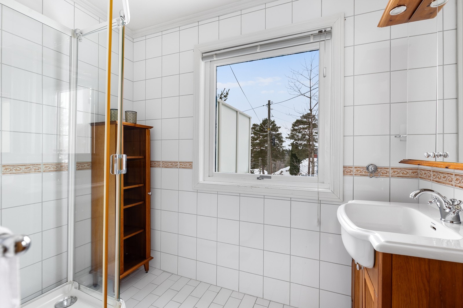 Lyst, flislagt bad med dusjkabinett og baderomsinnredning Galleribilde